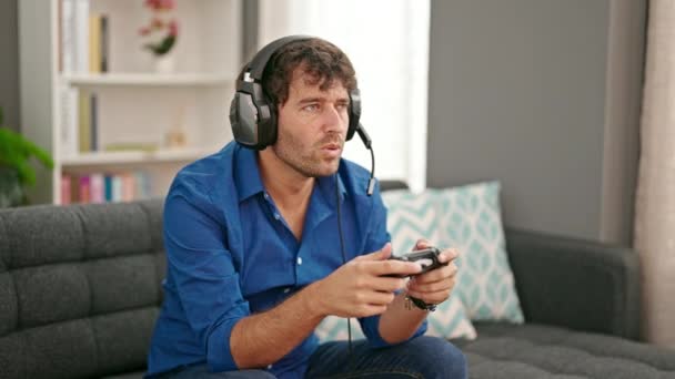 自宅で動揺しているようにビデオゲームをプレイしている若いヒスパニック男性 — ストック動画