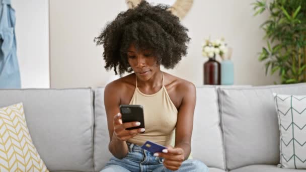Afroamerykanka Zakupy Smartfonem Kartą Kredytową Zaskoczony Domu — Wideo stockowe