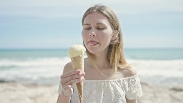 Młoda Blondynka Turystka Uśmiecha Się Pewnie Jedząc Lody Nad Morzem — Wideo stockowe