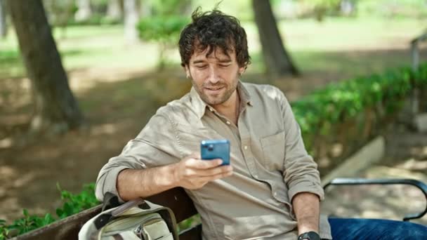 Νεαρός Ισπανός Που Χρησιμοποιεί Smartphone Καθισμένος Στον Πάγκο Κάνοντας Μια — Αρχείο Βίντεο
