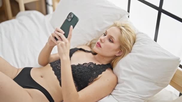 Young Blonde Woman Wearing Lingerie Using Smartphone Bedroom — Stockvideo