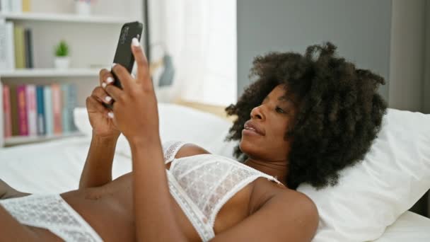 Αφροαμερικανή Γυναίκα Που Χρησιμοποιεί Smartphone Ξαπλωμένη Στο Κρεβάτι Και Δείχνει — Αρχείο Βίντεο