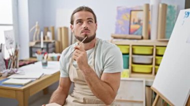 Genç İspanyol ressam resim stüdyosunda düşünüyor.