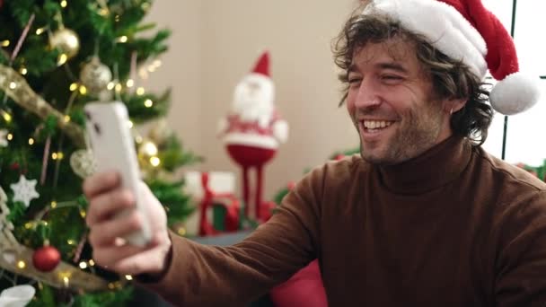 Jovem Hispânico Ter Vídeo Chamada Sentado Sofá Pela Árvore Natal — Vídeo de Stock