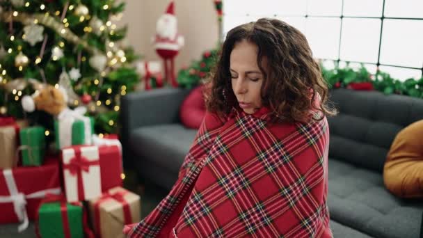 Латиноамериканка Средних Лет Покрытая Одеялом Сидит Диване Рождественской Елки Кашляет — стоковое видео