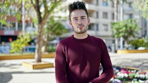 Молодий Іспаномовний Чоловік Стоїть Серйозним Виразом Руками Схрестив Жест Парку — стокове відео