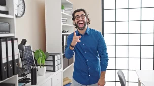 若いヒスパニックの男のビジネスワーカーは オフィスでカメラを指す自信を持って微笑みます — ストック動画