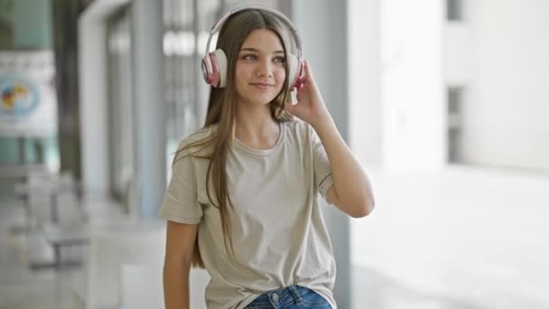 Νεαρό Όμορφο Κορίτσι Ακούει Μουσική Και Χορεύει Στη Βιβλιοθήκη — Αρχείο Βίντεο