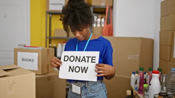 African American Woman Volunteer Holding Donate Now Message Charity Center — Video