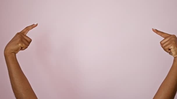 非洲裔美国女人指着空旷的空间 用大拇指在孤立的粉色背景上做手势 — 图库视频影像