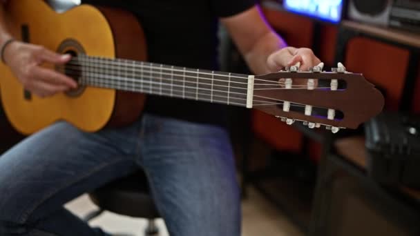 若いヒスパニック系の男のミュージシャンが音楽スタジオでクラシックギターを演奏 — ストック動画