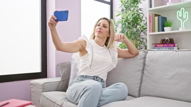 Young Blonde Woman Taking Selfie Picture Smartphone Sitting Sofa Home — Stock video