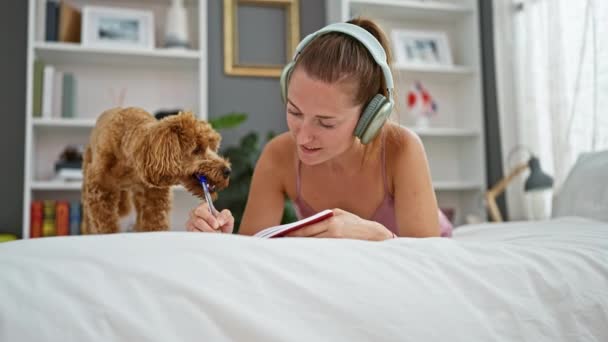 Junge Kaukasische Frau Mit Hund Schreibt Auf Notizbuch Und Hört — Stockvideo