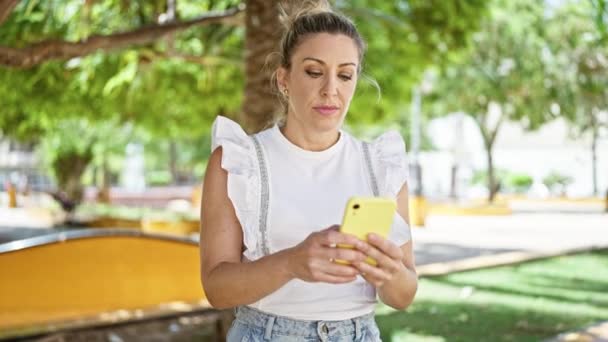 Mujer Rubia Joven Usando Smartphone Celebrando Parque — Vídeo de stock