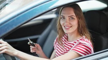 Sokakta kendine güvenen genç sarışın kadın gülümsüyor.