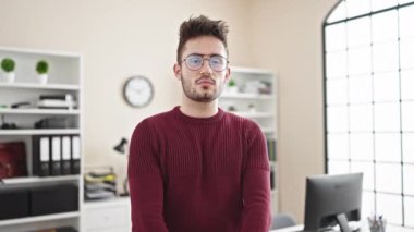 Genç İspanyol iş adamı gülümseyen, kendine güvenen, kollarını kavuşturup ofiste el kol kola duran.