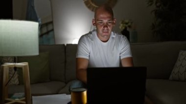 Genç İspanyol adam dizüstü bilgisayar kullanıyor evde yorgun kahve içiyor.
