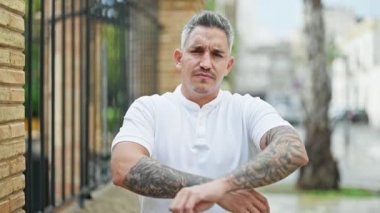 Çapraz kollu ve ciddi yüzlü İspanyol genç adam.