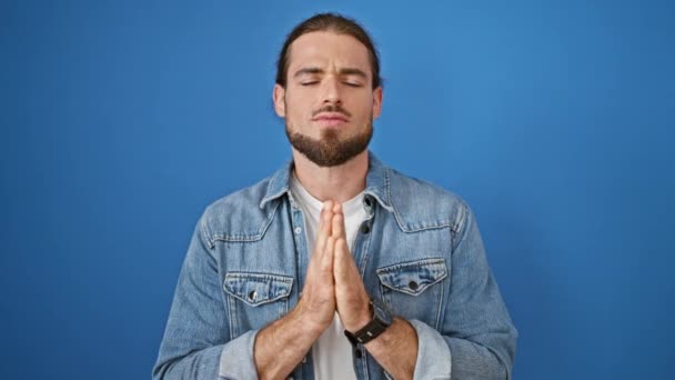年轻的惊慌失措的男人为孤独的蓝色背景祈祷 — 图库视频影像
