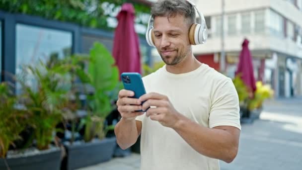 Молодий Чоловік Використовує Смартфон Навушниках Вулиці — стокове відео