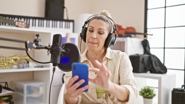 Młoda Blondynka Reporter Mówi Radiu Pomocą Smartfona Studio Radiowym — Wideo stockowe