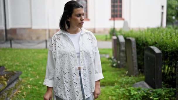 公園で墓石を歩いている美しい若いヒスパニックの女性 — ストック動画