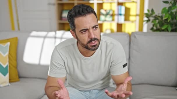 Young Hispanic Man Sitting Sofa Speaking Home — Stock Video