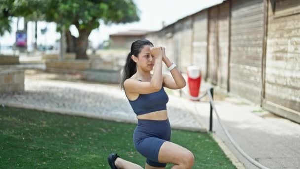 Young Beautiful Hispanic Woman Wearing Sportswear Training Legs Exercise Park — Stock Video