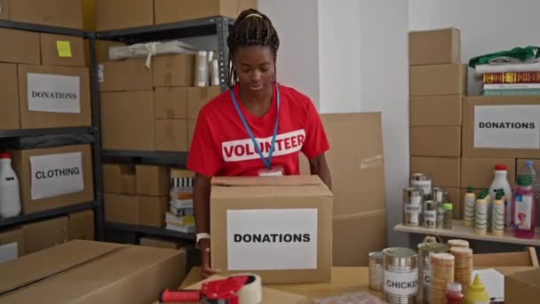 Femme Afro Américaine Bénévole Souriant Confiant Tenant Paquet Dons Bureau — Video