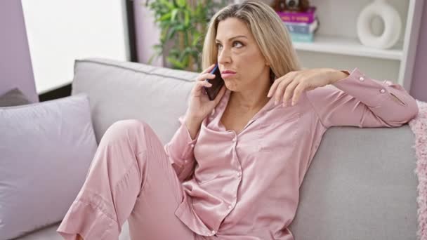 Mujer Rubia Joven Hablando Teléfono Inteligente Sentado Sofá Con Cara — Vídeos de Stock