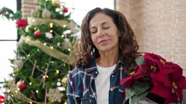 Medelålders Latinamerikansk Kvinna Som Håller Julväxt Hemma — Stockvideo