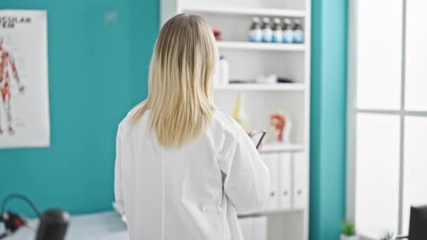 Ung Blond Kvinna Läkare Ler Säker Håller Medicinsk Rapport Kliniken — Stockvideo