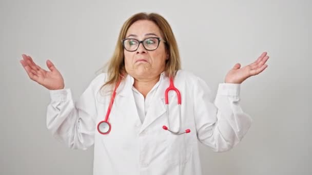 Midaldrende Spansktalende Kvinde Læge Stående Clueless Isoleret Hvid Baggrund – Stock-video