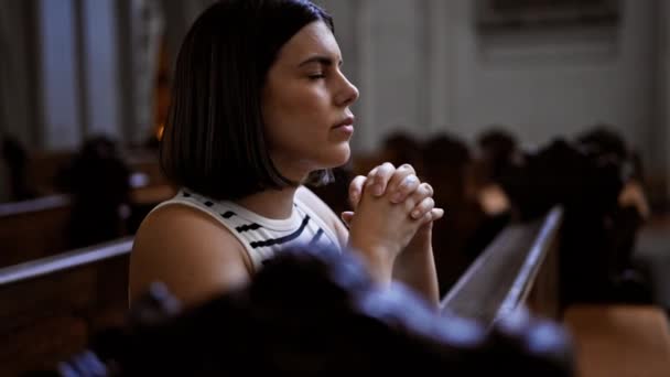 ウィーンのアウグスティヌス教会の教会のベンチで祈っている若い美しいヒスパニック女性 — ストック動画