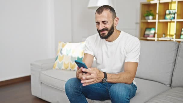 Joven Hombre Hispano Hablando Smartphone Sentado Sofá Casa — Vídeos de Stock