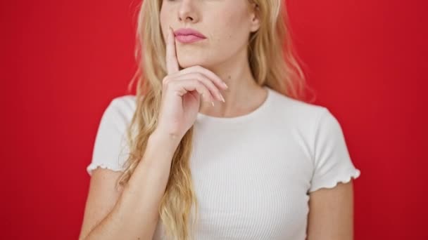 Jeune Femme Blonde Debout Avec Expression Doute Sur Fond Rouge — Video