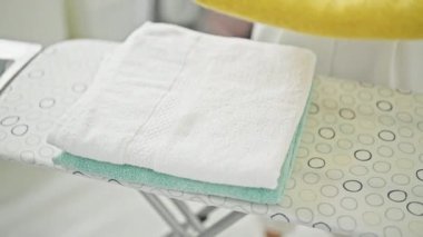 Çamaşır odasında havlu katlayan genç sarışın kadın.