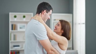 Güzel bir çift ayakta birbirlerine sarılıyor ve evde öpüşüyorlar.