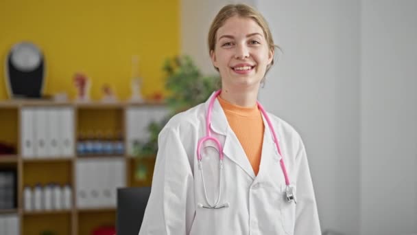 若い金髪女性医師はクリニックでOkジェスチャーを行います — ストック動画