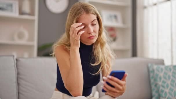 Jeune Femme Blonde Utilisant Smartphone Assis Sur Canapé Maison — Video