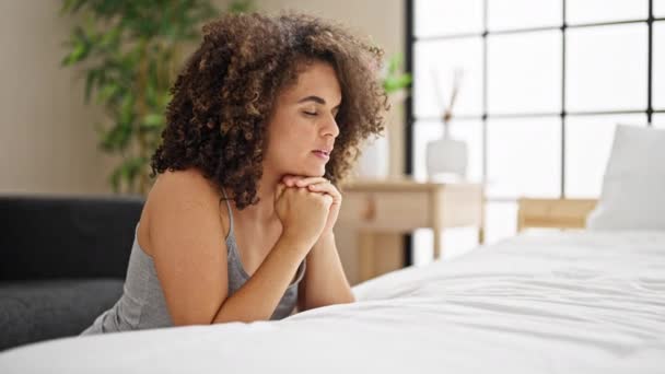 ベッドルームで祈っている床に座っている若い美しいヒスパニック女性 — ストック動画