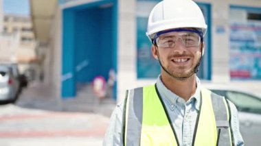 Kafkasyalı genç mimar inşaat alanında kendine güvenerek gülümsüyor.