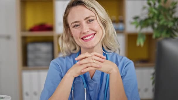 Young Blonde Woman Doctor Smiling Confident Sitting Table Clinic — Wideo stockowe