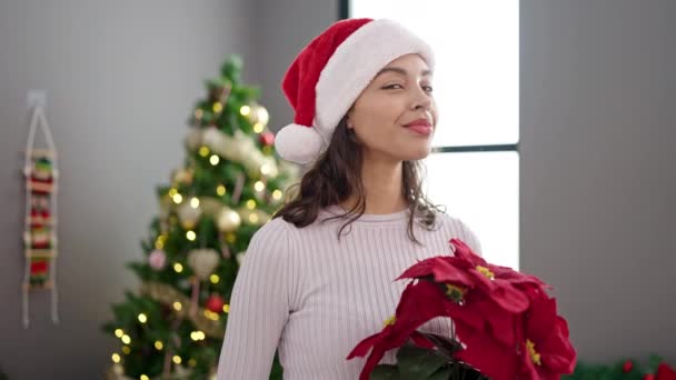Νεαρή Όμορφη Ισπανόφωνη Γυναίκα Που Κρατάει Χριστουγεννιάτικο Φυτό Στο Σπίτι — Αρχείο Βίντεο