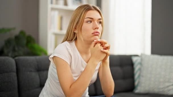 Young Blonde Woman Sitting Sofa Serious Expression Home — 图库视频影像