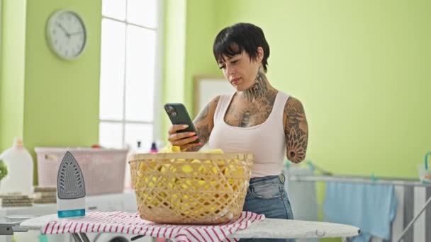 Hispánská Žena Amputovaným Ramenem Pomocí Smartphonu Stojící Žehlícího Stolu Prádelně — Stock video