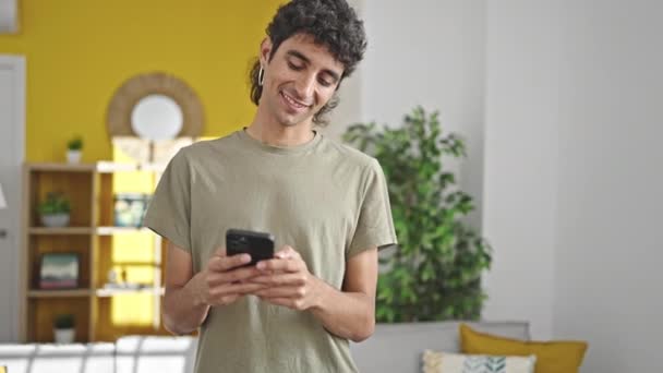 Jonge Spaanse Man Met Smartphone Zittend Bank Thuis — Stockvideo