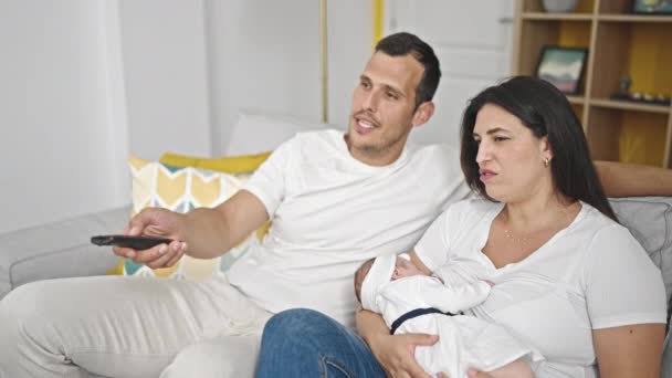 Οικογένεια Των Τριών Βλέποντας Τηλεόραση Κάθεται Στον Καναπέ Στο Σπίτι — Αρχείο Βίντεο