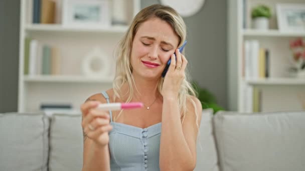 Młoda Blondynka Rozmawia Smartfonie Testem Ciążowym Płacząc Domu — Wideo stockowe