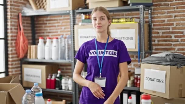 若い金髪の女性ボランティア チャリティセンターで腕で立って自信を持って笑顔 — ストック動画